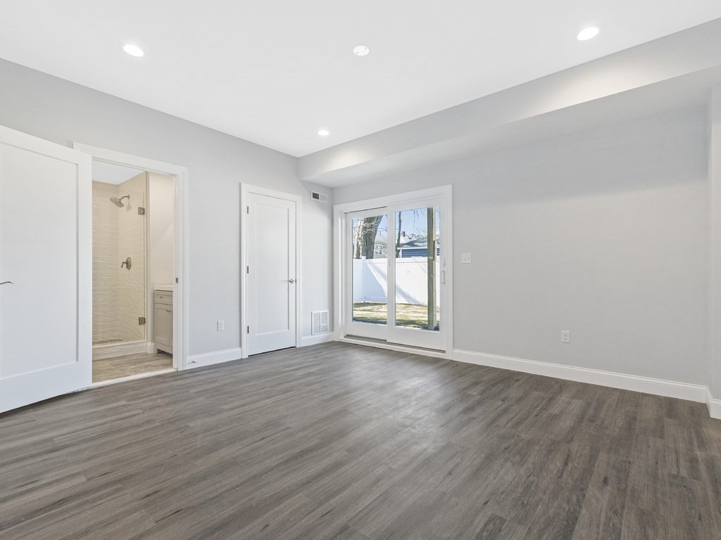 83 Parmenter Road, Unit 2 Waltham, MA 02453 - Photo 30 of 36 a view of an empty room with wooden floor and a window