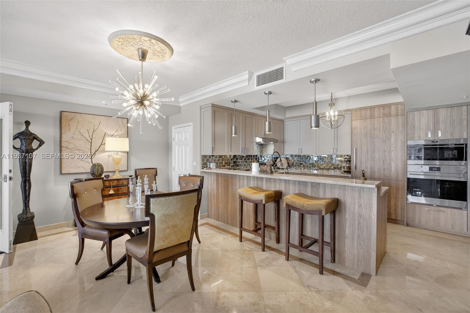 100 South Birch Road, Unit 1103F Fort Lauderdale, FL 33316 - Photo 28 of 80 Spectacular kitchen w/ custom bleached walnut veneer cabinetry by renowned Chicago based millworker. Grain matches from top to bottom. Wolf induction cooktop & double oven (w/ microwave / convenction at top oven), Sub Zero Refrigerator & Beverage Cooler, Miele Dishwasher. Antiqued mirror backsplash