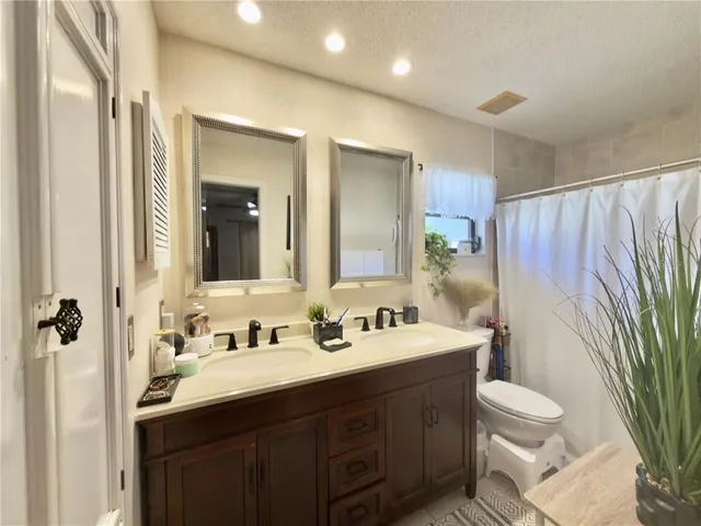a bathroom with a double vanity sink toilet and shower