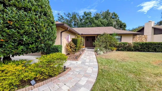 a front view of a house with a yard and potted plants