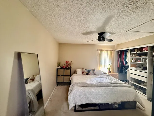 a bedroom with a bed and a large mirror on the dresser