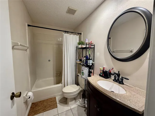 a bathroom with a granite countertop sink a toilet and a mirror