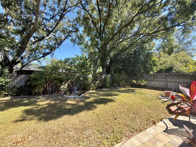 a view of swimming pool with lawn chairs and wooden fence
