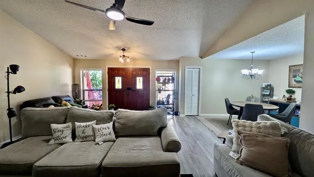 a living room with furniture or chandelier and a wooden floor