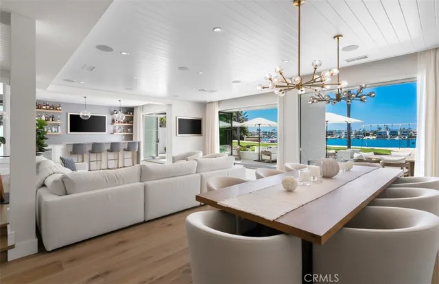 a large living room with stainless steel appliances granite countertop furniture a fireplace a rug and a large window