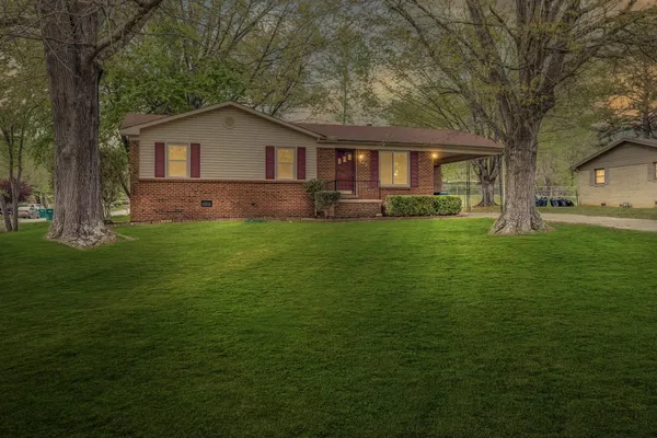 a view of a house with a yard and sitting area