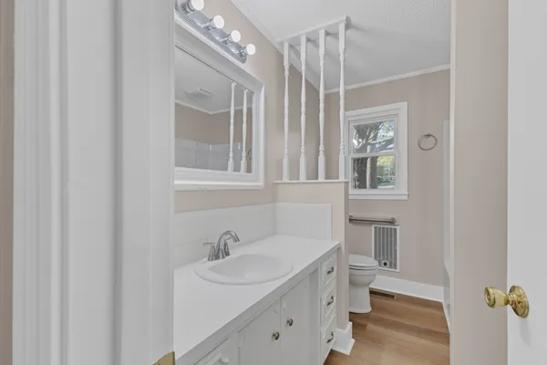 a bathroom with a sink and mirror with toilet
