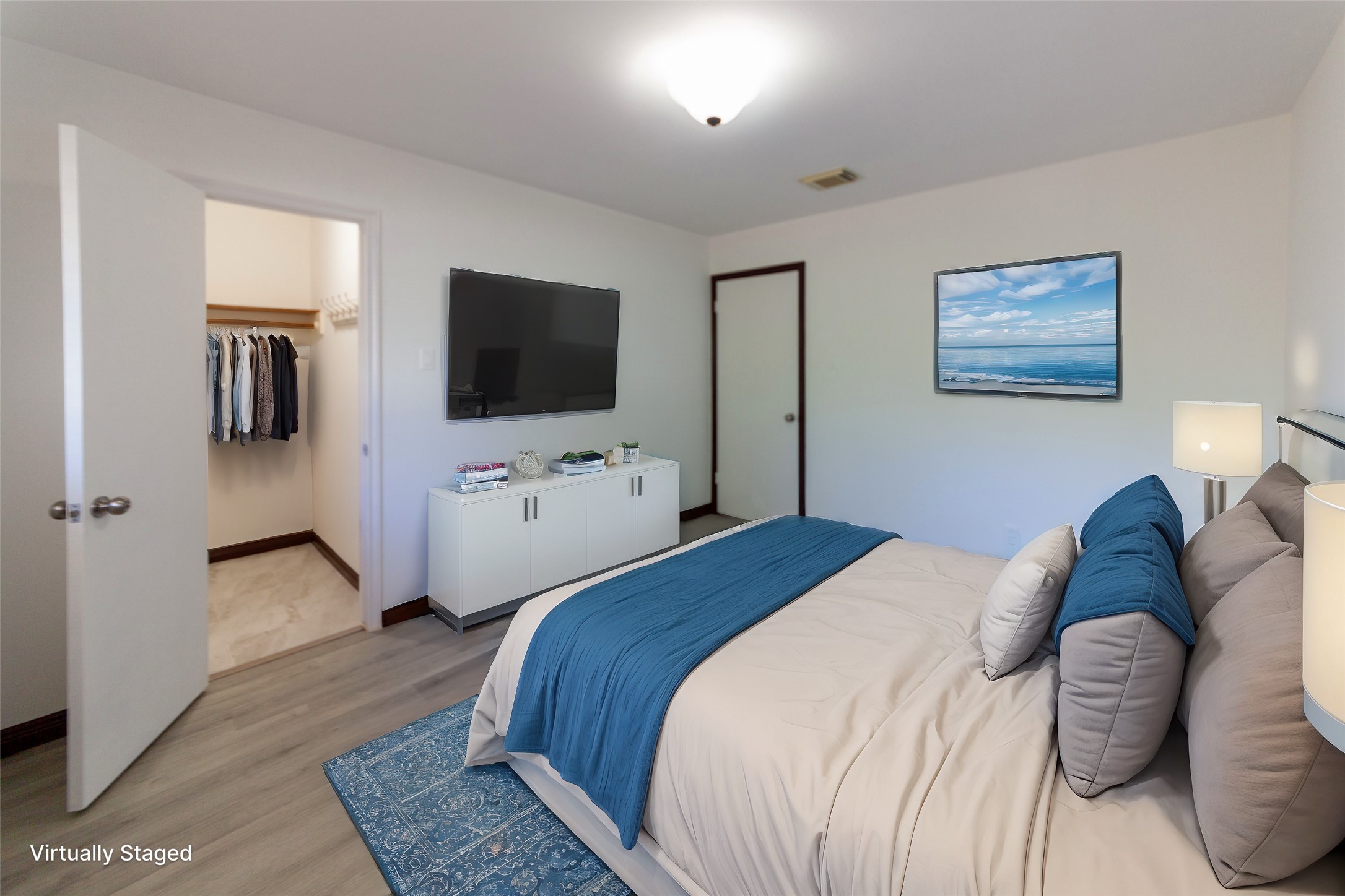 8826 Roos Road Houston, TX 77036 - Photo 29 of 42 This virtually staged bedroom 4 features a cozy layout with neutral walls, and a comfortable bed accented by blue bedding. A walk-in closet offers ample storage, and the room is well-lit with modern fixtures.