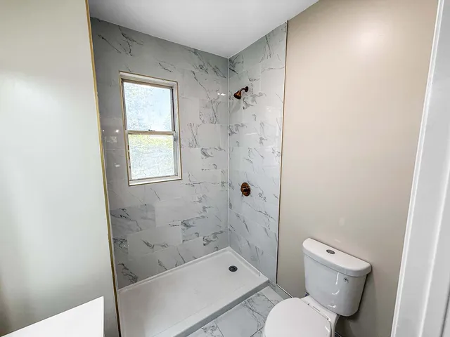 a bathroom with a toilet and shower