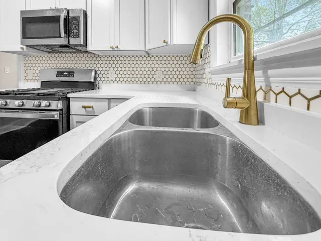 a kitchen with a sink a stove and cabinets