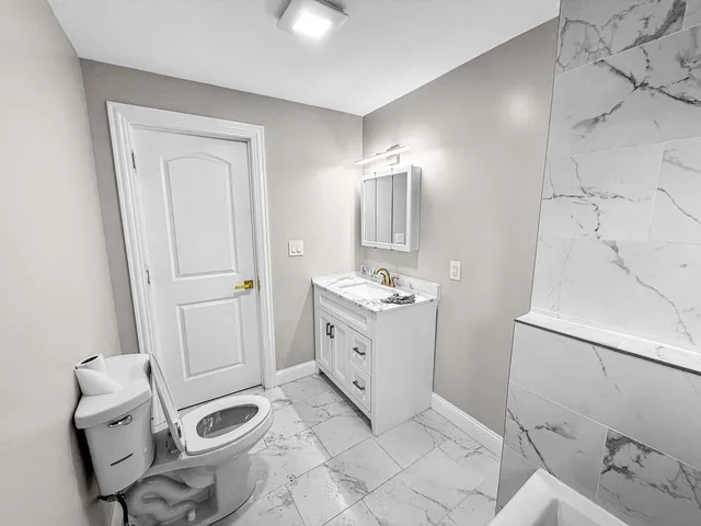 a bathroom with a sink toilet and mirror