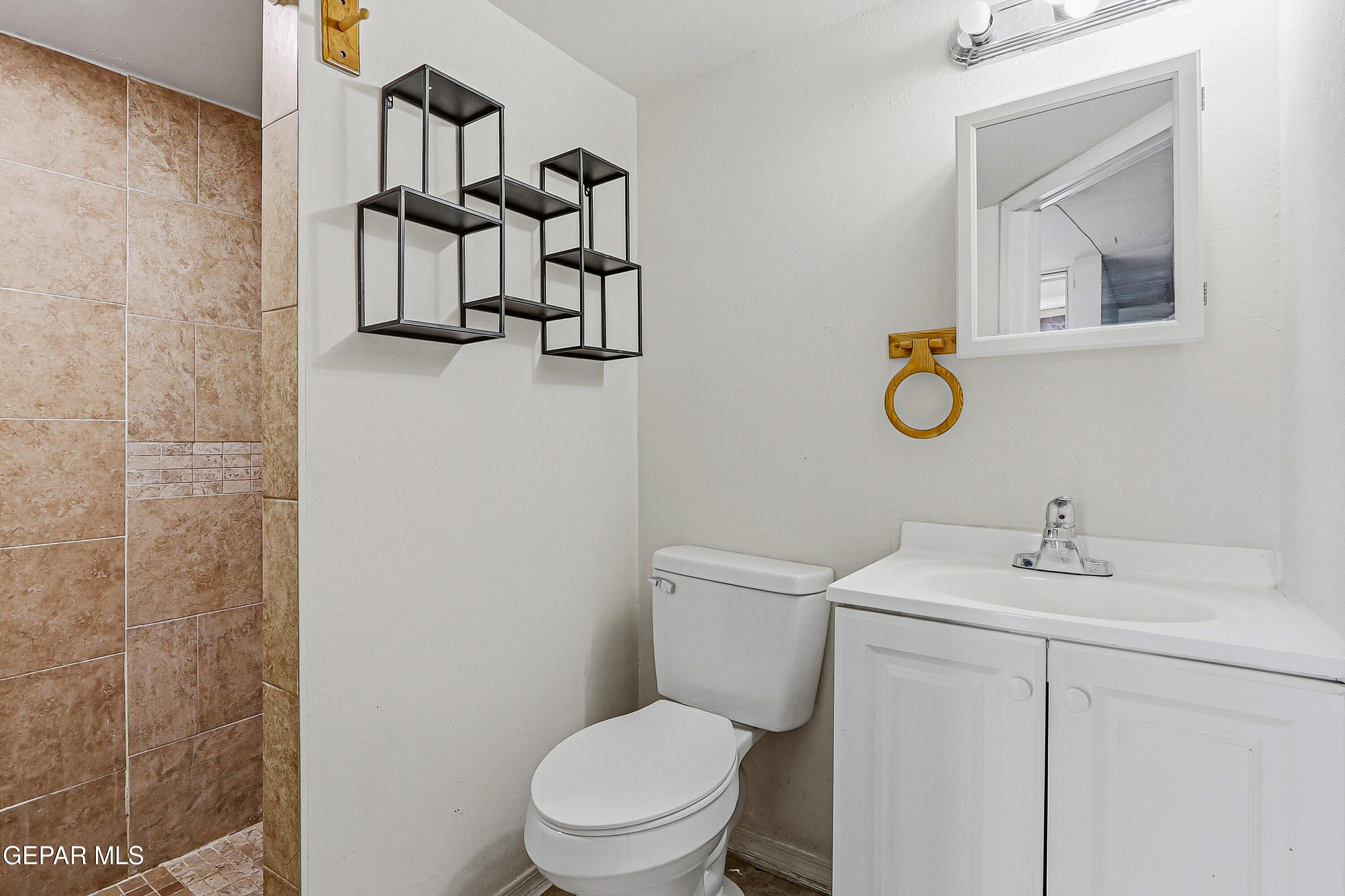 11548 Jenny Road Socorro, TX 79927 - Photo 32 of 39 a bathroom with a toilet sink vanity and mirror