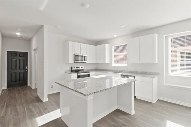 a kitchen with stainless steel appliances granite countertop a stove a sink and a refrigerator