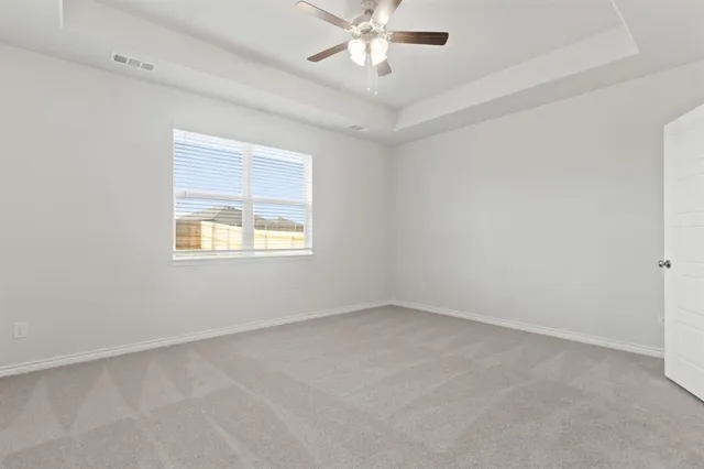 an empty room with a window and a fan