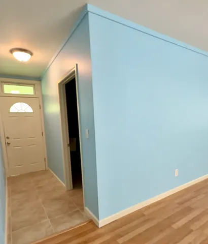 an empty room with wooden floor and mirror