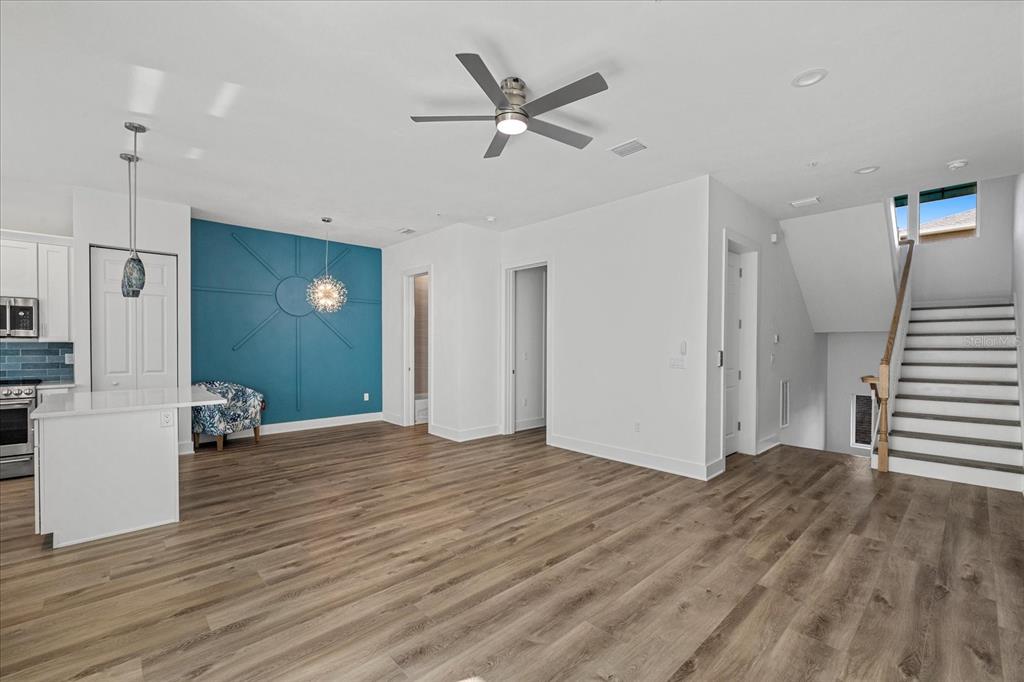 15405 Gulf Boulevard, Unit B2 Madeira Beach, FL 33708 - Photo 12 of 49 a view of an empty room with wooden floor and a ceiling fan