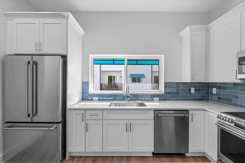 15405 Gulf Boulevard, Unit B2 Madeira Beach, FL 33708 - Photo 14 of 49 a kitchen with white cabinets and a refrigerator