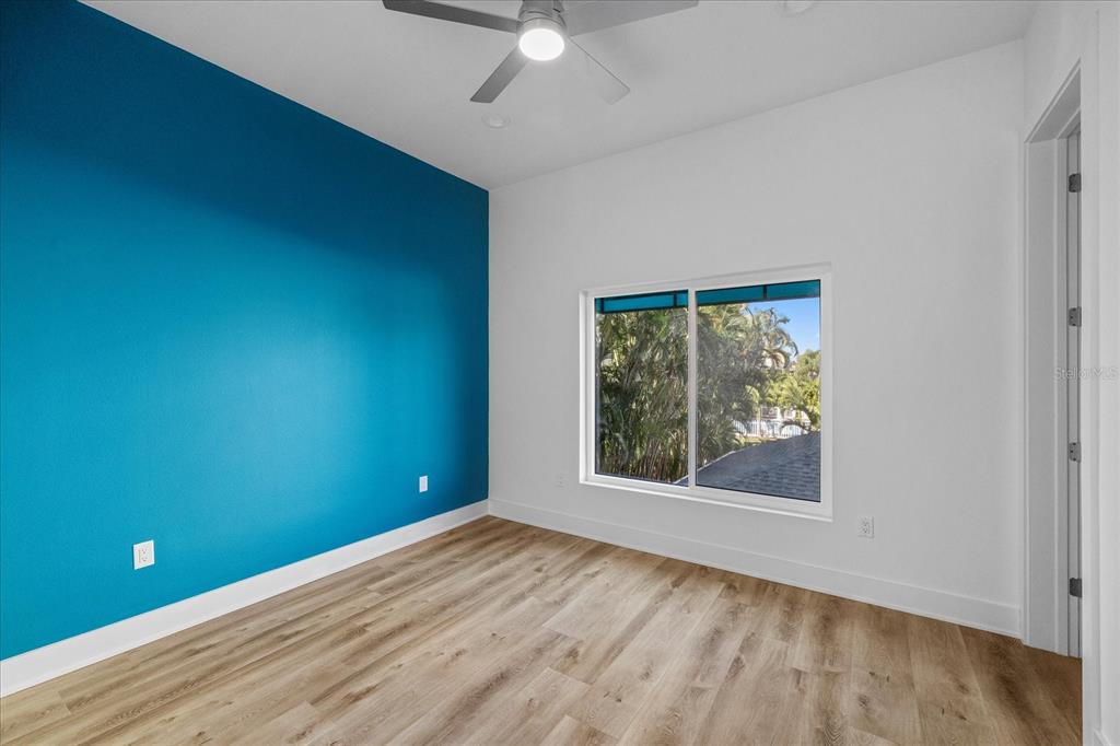 15405 Gulf Boulevard, Unit B2 Madeira Beach, FL 33708 - Photo 19 of 49 an empty room with wooden floor and windows
