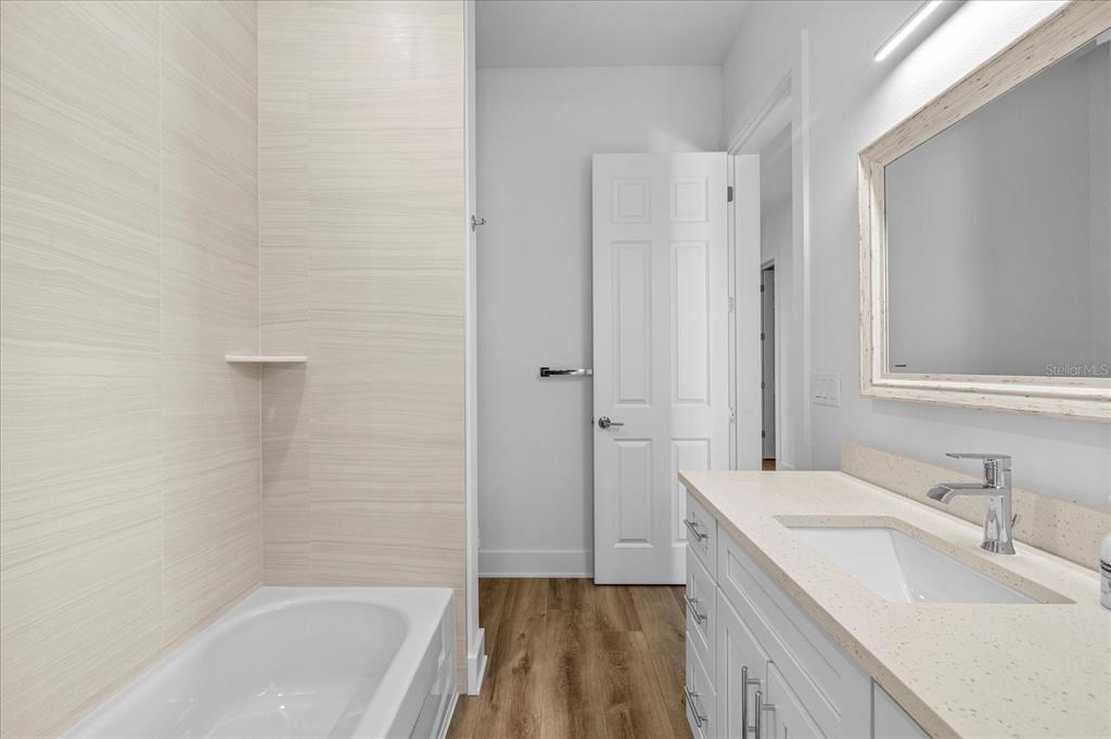 15405 Gulf Boulevard, Unit B2 Madeira Beach, FL 33708 - Photo 22 of 49 a bathroom with a granite countertop sink a mirror and a bathtub