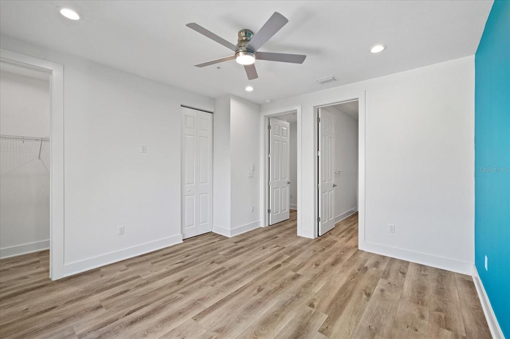 15405 Gulf Boulevard, Unit B2 Madeira Beach, FL 33708 - Photo 28 of 49 an empty room with wooden floor and ceiling fan