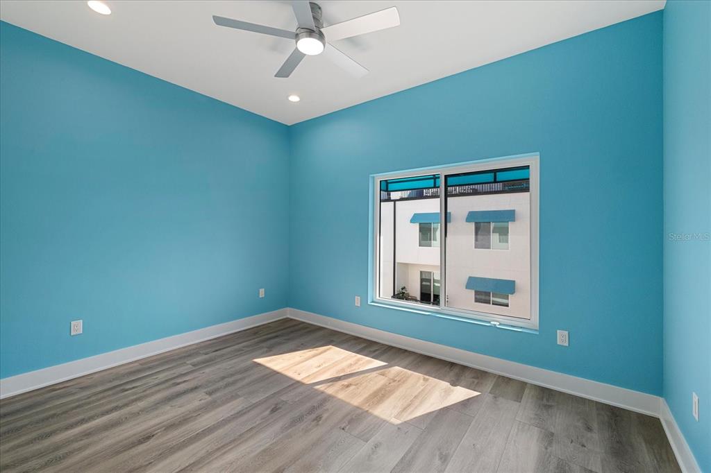 15405 Gulf Boulevard, Unit B2 Madeira Beach, FL 33708 - Photo 29 of 49 an empty room with wooden floor fan and windows