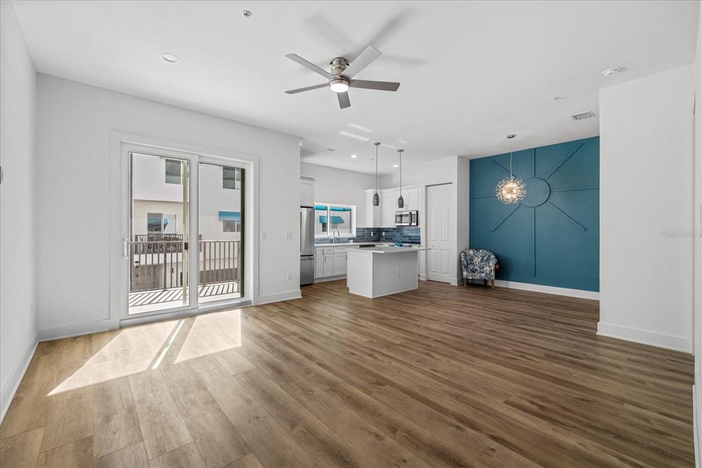 15405 Gulf Boulevard, Unit B2 Madeira Beach, FL 33708 - Photo 10 of 49 a view of a kitchen with wooden floor and a ceiling fan