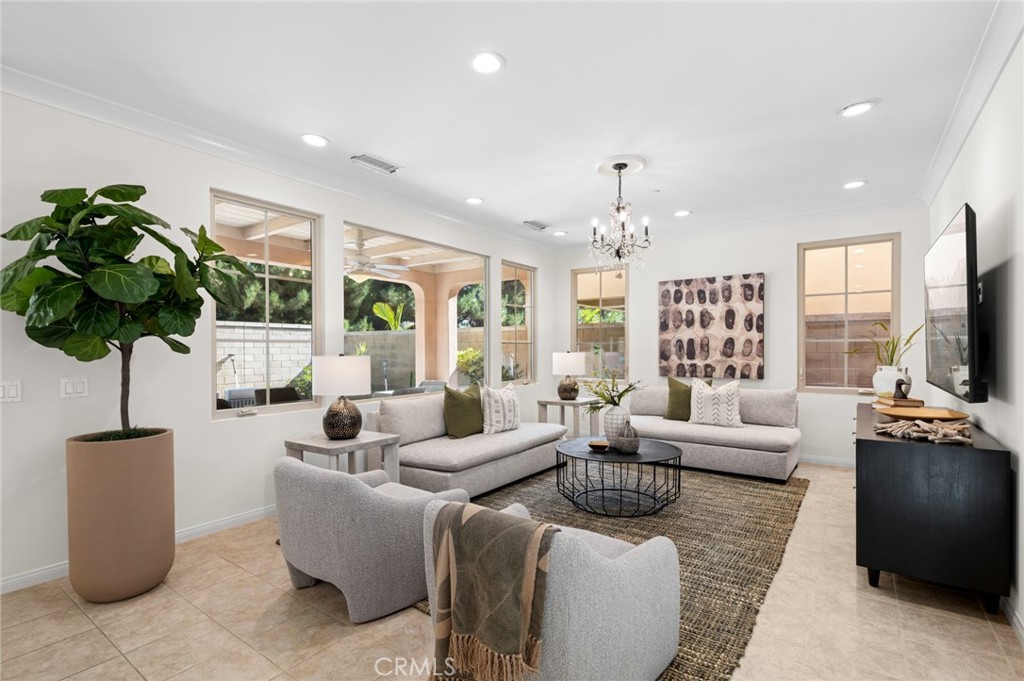 a living room with furniture a chandelier and a flat screen tv