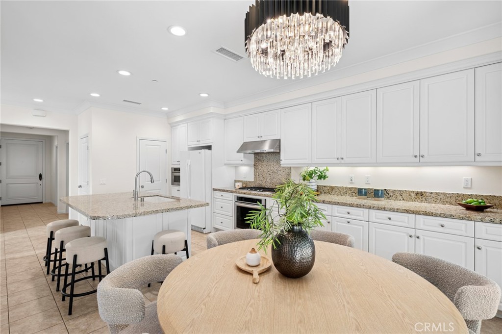 61 Lupari Irvine, CA 92618 - Photo 14 of 65 a kitchen with a white cabinets and chairs