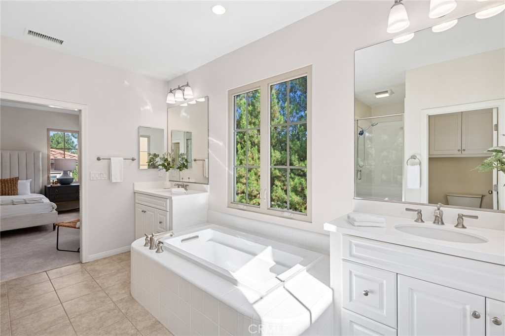 61 Lupari Irvine, CA 92618 - Photo 25 of 65 a bathroom with a sink a large mirror and a bathtub