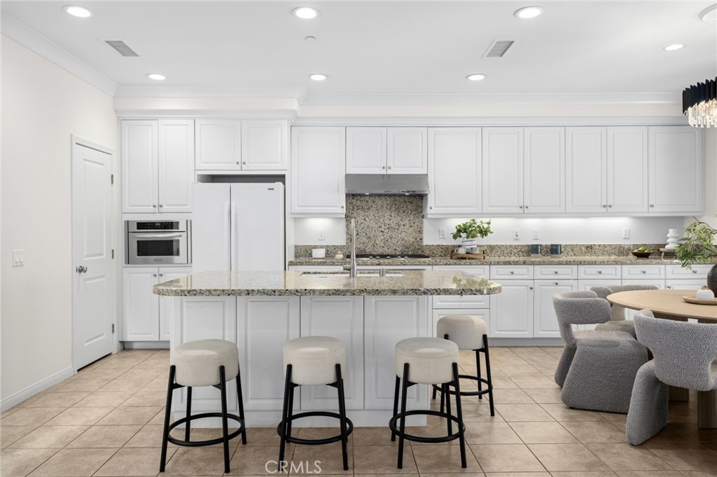 61 Lupari Irvine, CA 92618 - Photo 4 of 65 a kitchen with stainless steel appliances granite countertop a table and chairs in it