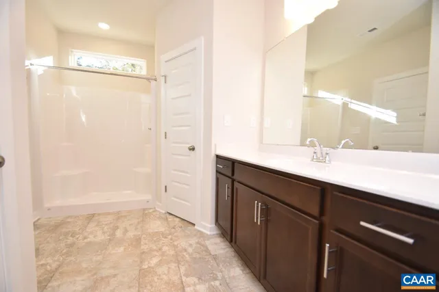 a bathroom with a double vanity sink a mirror and shower