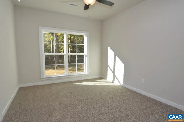 an empty room with a window and a ceiling fan
