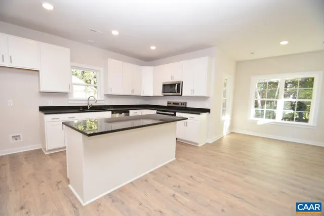 a kitchen with stainless steel appliances granite countertop a sink and a stove top oven