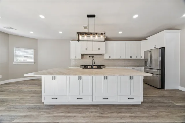 a kitchen with stainless steel appliances a refrigerator sink and cabinets