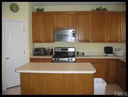 7616 Silver View Lane Raleigh, NC 27613 - Photo 5 of 10 a kitchen with stainless steel appliances a stove a sink a refrigerator and cabinets