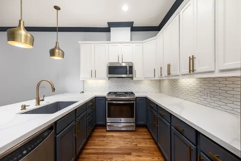 a kitchen with stainless steel appliances granite countertop a sink and a microwave
