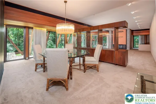 a dining room with furniture and a large window