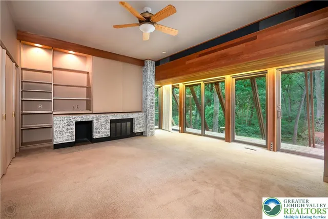 a view of an empty room with a fireplace and a window