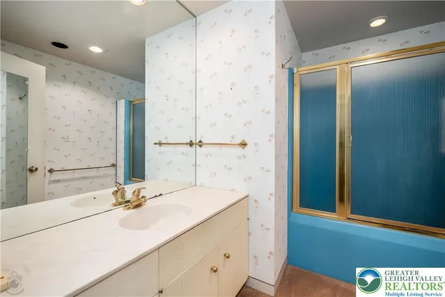 a bathroom with a sink shower and a mirror