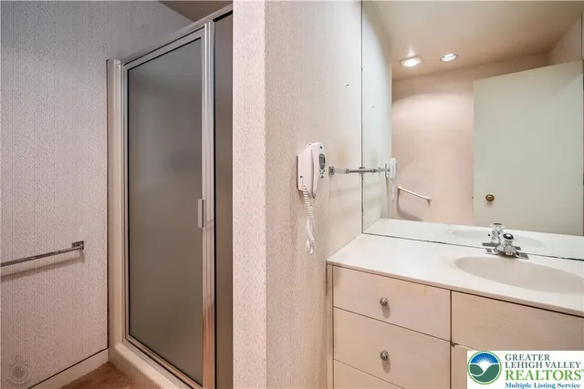 a view of an empty room with cabinet and mirrors