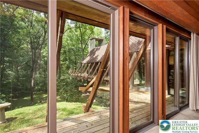 a view of a room with a large window and wooden floor