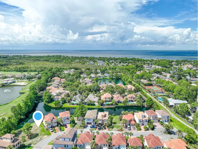 an aerial view of residential houses with outdoor space and lake view in back