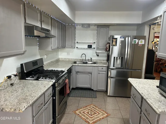 a kitchen with stainless steel appliances granite countertop a stove and a refrigerator