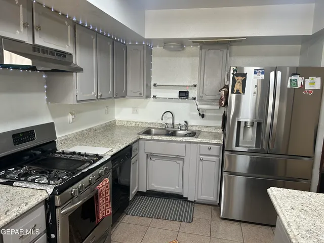 a kitchen with granite countertop a stove and a sink