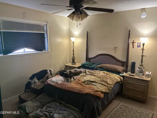 a view of a hallway with a chandelier fan and a bathroom