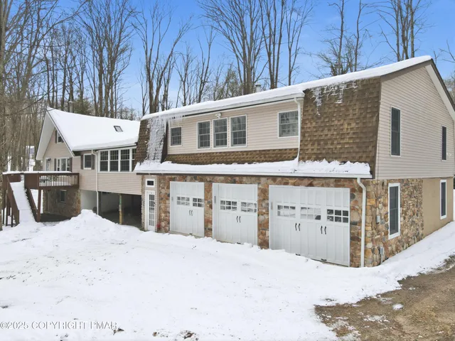 a view of a house with a yard covered in snow
