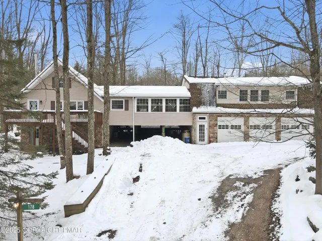 a view of a white house with a snow in the background