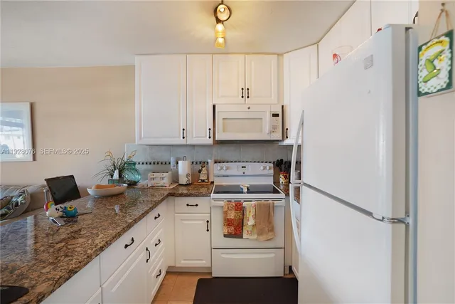 a kitchen with stainless steel appliances white cabinets and a refrigerator