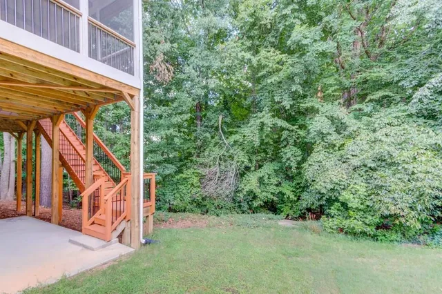 a view of an empty room with wooden floor and windows