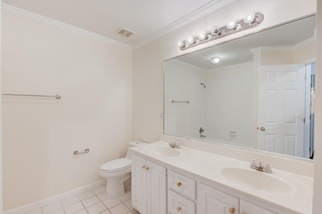 2405 Millwater Crossing Northeast Dacula, GA 30019 - Photo 32 of 63 a bathroom with a toilet a sink a mirror and a shower